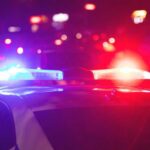Costco Chaos: Machete Mayhem Stopped Police car with flashing red and blue lights at night