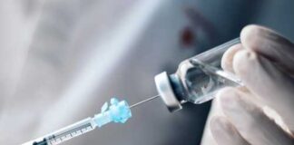 A healthcare professional preparing a syringe from a vial