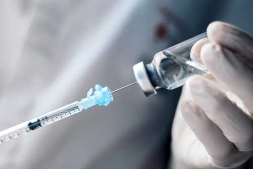 Injecting,Injection,Vaccine,Vaccination,Medicine,Into,A,Syringe,Woman,Nurse A healthcare professional preparing a syringe from a vial