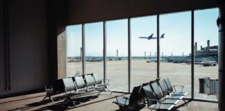 View of an airport waiting area with an airplane taking off in the background