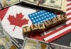 Wooden blocks spelling tariffs on U.S. and Canadian flags with dollar bills