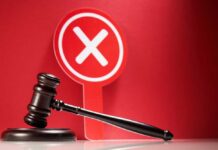 Judge's gavel with red cross sign in background