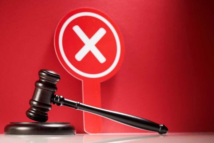 Judge's gavel with red cross sign in background