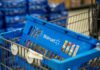 Blue shopping basket in a cart at a supermarket aisle