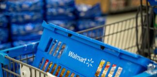 Blue shopping basket in a cart at a supermarket aisle
