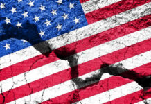 Cracked United States flag on textured surface.