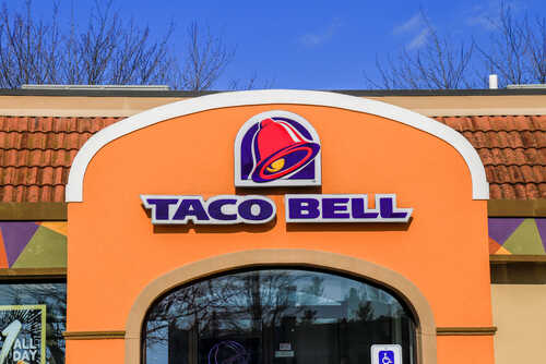 Exterior view of a Taco Bell restaurant with a colorful sign