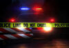 Drive-Thru Turns Deadly War Zone Police car with flashing lights behind caution tape.