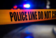 Creepy Cops Caught Using Spy Tool For THIS?! Police tape with flashing lights in the background.