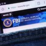 Supreme Court Panic: Walls, Guns, Millions Mobile phone displaying the FBI website in a denim pocket
