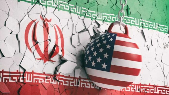 shutterstock_1164296512 A wrecking ball painted with the American flag is breaking through a wall featuring the Iranian flag