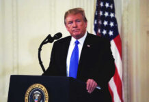 Donald Trump speaking at podium.