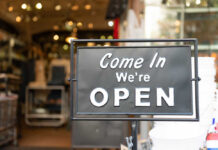 A black sign with white text that says 'Come In We're OPEN'