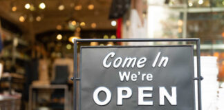 A black sign with white text that says 'Come In We're OPEN'