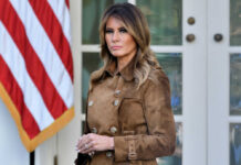 Melania Warns THESE Scams Target Kids Melania Trump standing outdoors in a brown suede trench coat