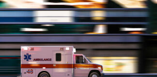 Ambulance driving through city street at speed