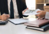 Two individuals engaged in a business transaction involving money and documents