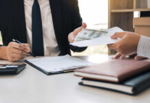 Two individuals engaged in a business transaction involving money and documents