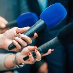 Liberty Island Horror: Arrest Hours Later Reporters holding colorful microphones