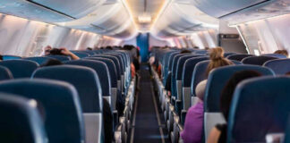 Airplane interior with passengers seated mid-flight.