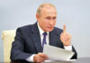 Kremlin Hardliner Targets U.S. Ally?! Vladimir Putin, holding papers, in a meeting.
