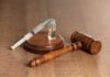 Hog Trail Killer’s Clock Ticks Toward Death A syringe and a vial placed next to a wooden gavel on a table