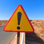 ALERT: 208,000 SUVs Risk Sudden Steering Loss Triangular warning road sign with exclamation mark on a rural highway
