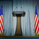 Podium between two American flags on a stage