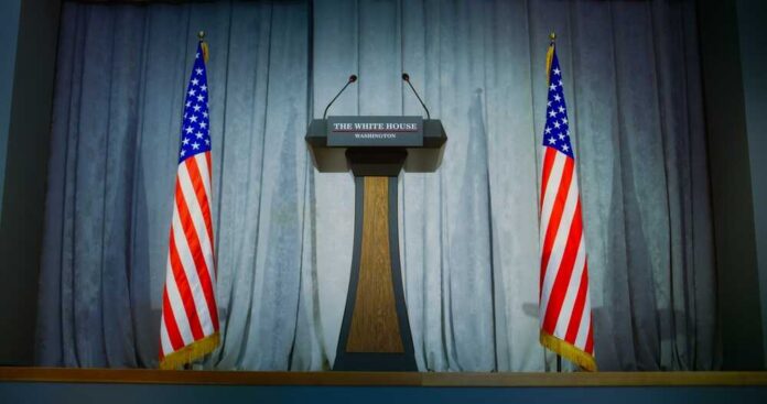 Podium between two American flags on a stage