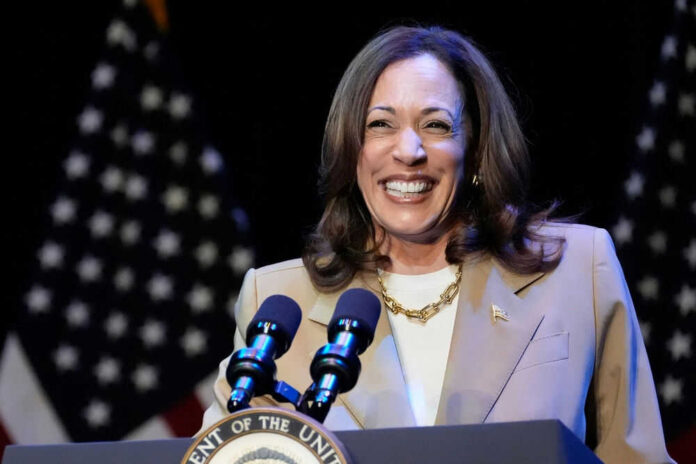 Kamala Harris smiling at a podium with microphones