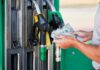 Diesel Hits Shocking Price – Grocery Pain Next Person holding cash at a gas station while preparing to refuel