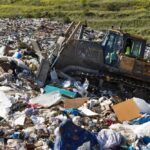 VIDEO: Garbage Mountain Buries a Neighborhood Bulldozer moving trash at a landfill site