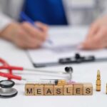 Coroner’s Alarm: First Measles Fatality Measles vaccine concept with stethoscope, syringe, and vials on doctor’s desk