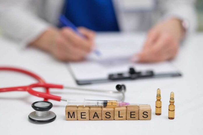 Measles vaccine concept with stethoscope, syringe, and vials on doctor’s desk