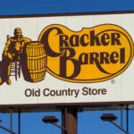 Cracker Barrel Old Country Store sign featuring a man sitting next to a barrel