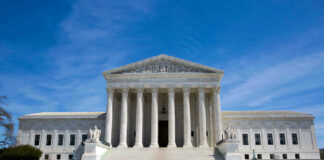 U.S. Supreme Court building under clear blue sky.
