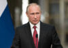 Vladimir Putin speaking at a podium with a microphone