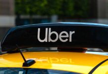 Uber sign on top of a yellow taxi