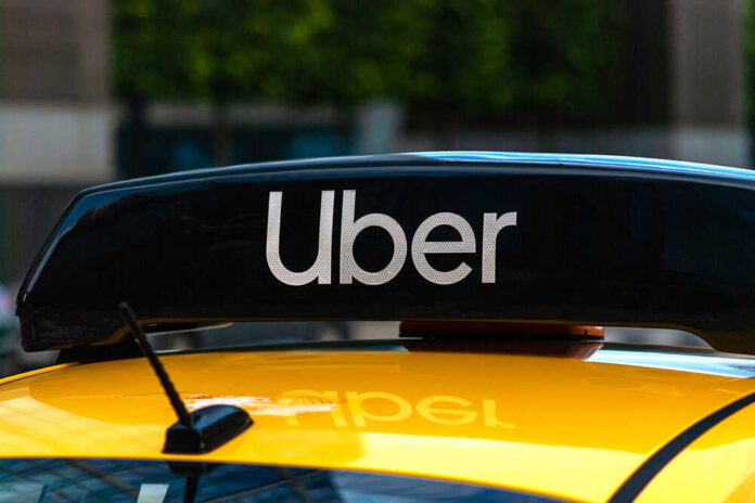 Uber sign on top of a yellow taxi
