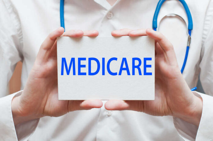 A medical professional holding a sign that says MEDICARE