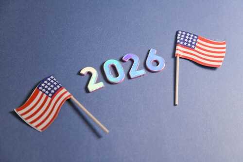 Two small American flags next to the numbers 2026 on a blue background