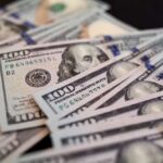 Surprise Checks Drop – What’s The Catch? Close-up of scattered hundred dollar bills