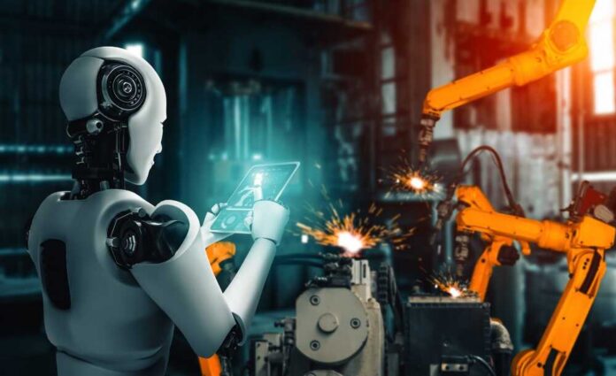A humanoid robot using a tablet in an industrial setting with robotic arms in action