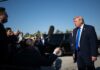 Donald Trump speaks to reporters outdoors near black SUVs